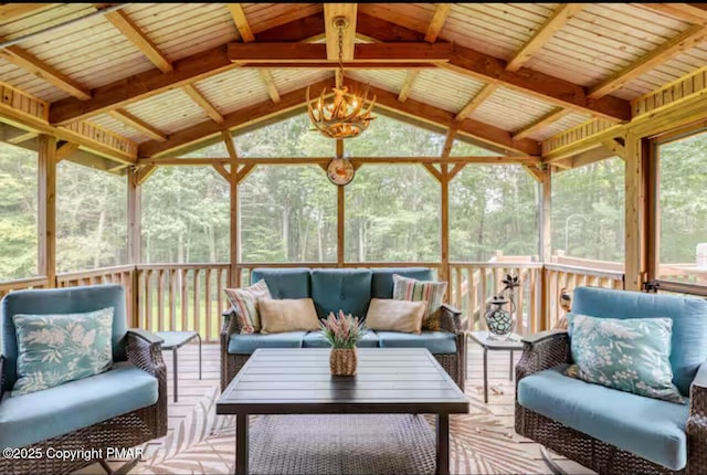 sunroom / solarium featuring vaulted ceiling and an inviting chandelier