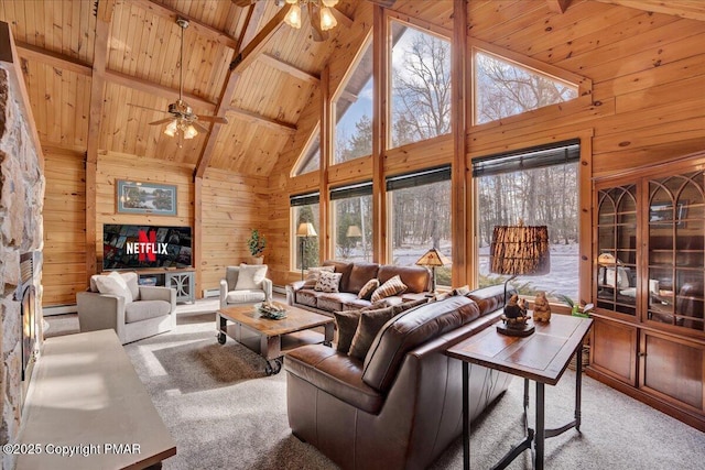 carpeted living room with wood ceiling, high vaulted ceiling, wooden walls, ceiling fan, and beam ceiling