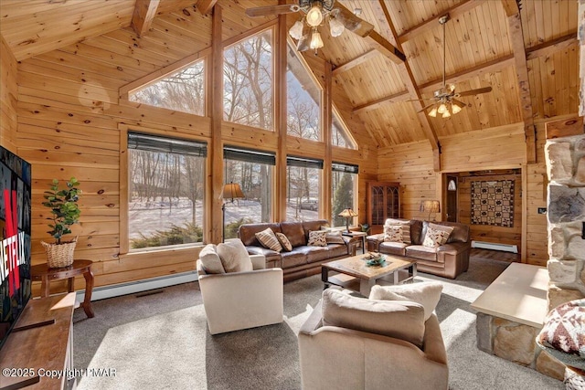 carpeted living area with wood ceiling, ceiling fan, wood walls, a baseboard heating unit, and beam ceiling