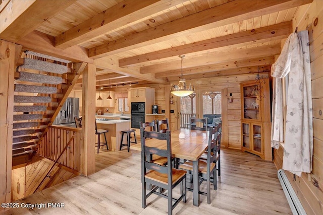 unfurnished dining area with wooden walls, wood ceiling, a baseboard radiator, light wood-style floors, and beam ceiling