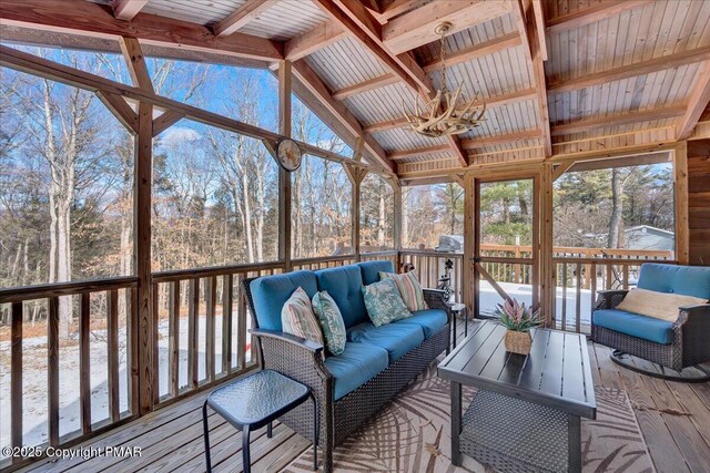 sunroom / solarium featuring vaulted ceiling with beams