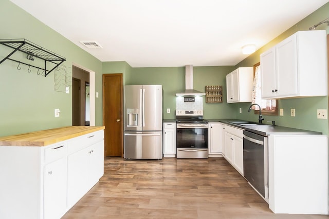 2227 Cheyenne Dr, Blakeslee, PA 18610 - kitchen with stainless steel appliances, wall chimney range hood, white cabinets, light wood finished floors, and wooden counters