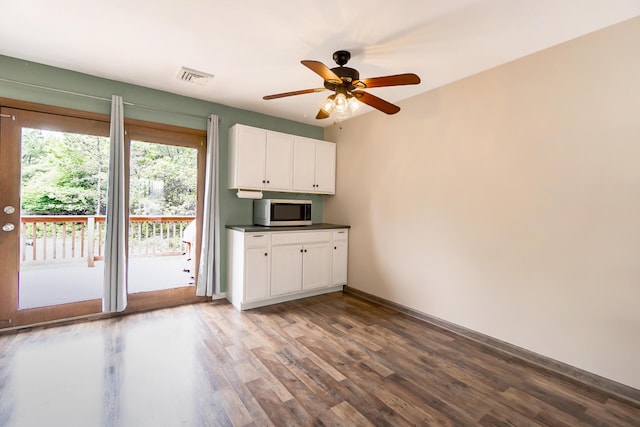 2227 Cheyenne Dr, Blakeslee, PA 18610 - kitchen featuring stainless steel microwave, white cabinetry, wood finished floors, and dark countertops
