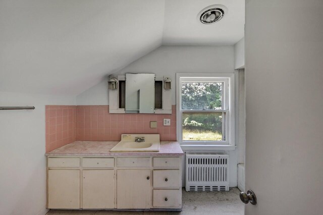 1198 W Main St, Stroudsburg, PA 18360 - bathroom with radiator heating unit, vaulted ceiling, vanity, and backsplash