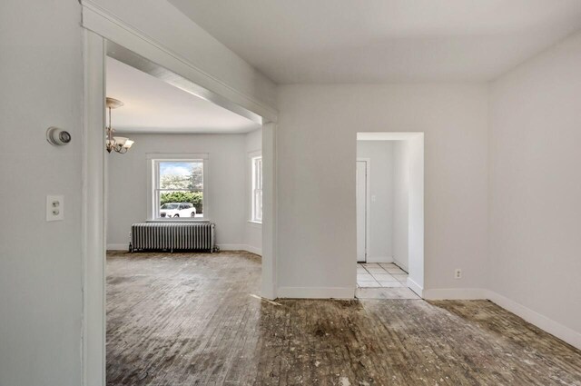 1198 W Main St, Stroudsburg, PA 18360 - spare room with radiator heating unit, wood finished floors, and a chandelier