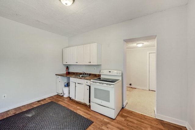 1198 W Main St, Stroudsburg, PA 18360 - kitchen with electric stove, dark countertops, light wood-style flooring, and white cabinetry