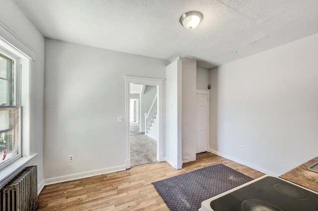 1198 W Main St, Stroudsburg, PA 18360 - unfurnished bedroom with radiator heating unit, wood finished floors, and a textured ceiling