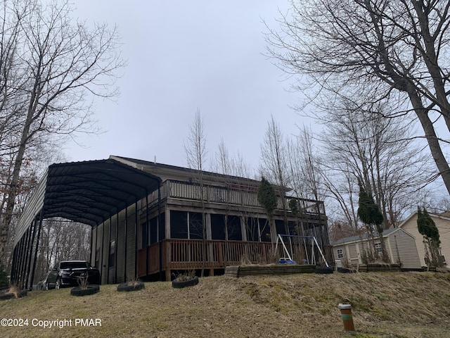 back of house with a carport and a wooden deck