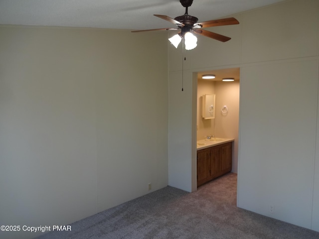 unfurnished bedroom featuring light colored carpet, connected bathroom, and a sink