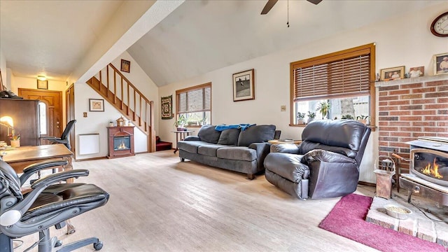 7924 Sleepy Hollow Dr, Tobyhanna, PA 18466 - living room featuring a wood stove, light wood-style flooring, stairs, a ceiling fan, and lofted ceiling