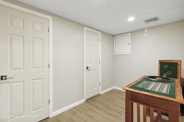 office space featuring light wood-type flooring, visible vents, and baseboards