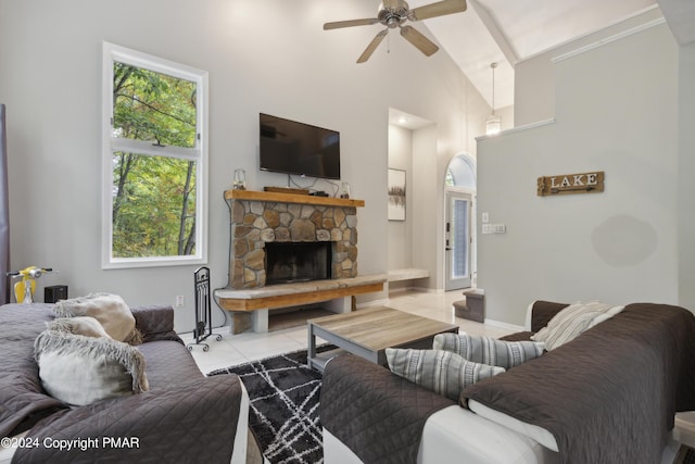 living room featuring high vaulted ceiling, tile patterned flooring, a fireplace, and ceiling fan