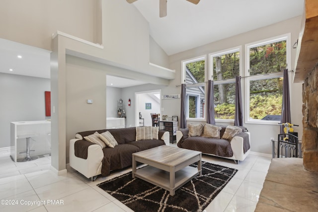 living area featuring high vaulted ceiling, ceiling fan, baseboards, and light tile patterned floors