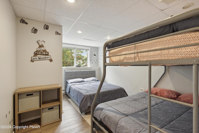 bedroom featuring recessed lighting, a drop ceiling, and wood finished floors