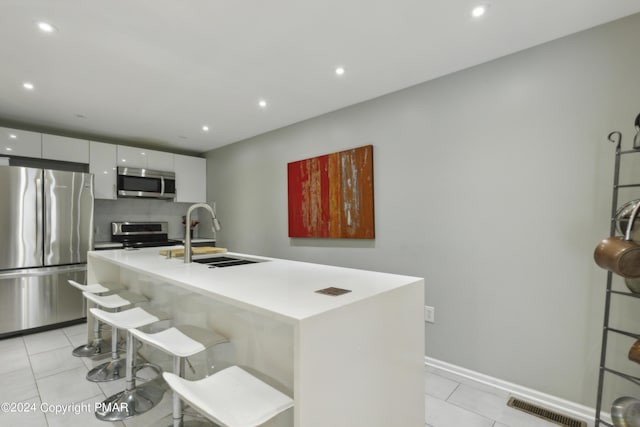 kitchen with light tile patterned floors, stainless steel appliances, a sink, and visible vents