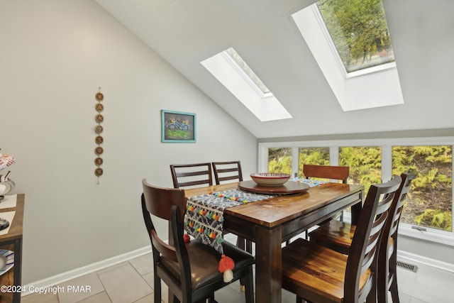 dining space with a healthy amount of sunlight, light tile patterned floors, visible vents, and lofted ceiling