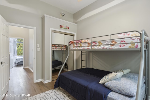 bedroom with a closet, baseboards, and wood finished floors