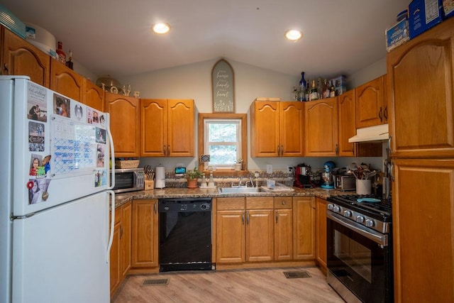 243 R Own Rd, East Stroudsburg, PA 18302 - kitchen with appliances with stainless steel finishes, under cabinet range hood, lofted ceiling, light wood finished floors, and brown cabinets