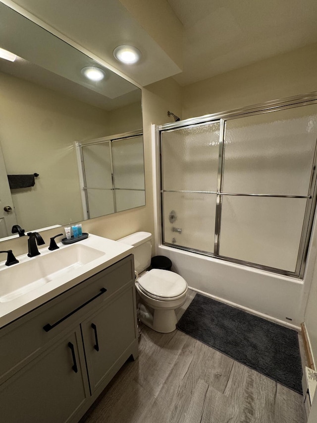 full bathroom with vanity, wood finished floors, bath / shower combo with glass door, and recessed lighting