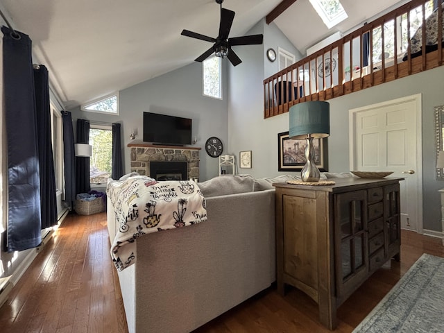 1161 Deer, Pocono Pines, PA 18350 - living area featuring ceiling fan, dark wood-style flooring, a skylight, a stone fireplace, and high vaulted ceiling