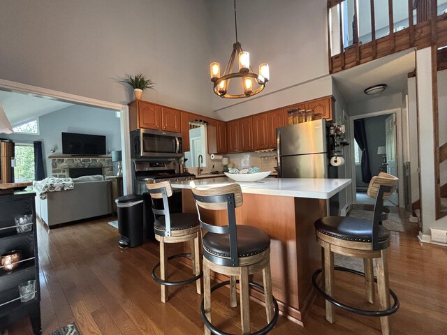 1161 Deer, Pocono Pines, PA 18350 - kitchen featuring appliances with stainless steel finishes, high vaulted ceiling, dark wood finished floors, brown cabinetry, and light countertops