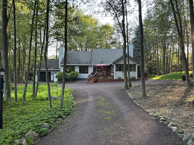 1161 Deer, Pocono Pines, PA 18350 - view of front of house with a chimney, driveway, a wooden deck, and a shingled roof