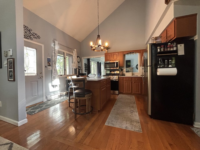 1161 Deer, Pocono Pines, PA 18350 - kitchen featuring appliances with stainless steel finishes, high vaulted ceiling, a kitchen island, dark wood finished floors, and a chandelier
