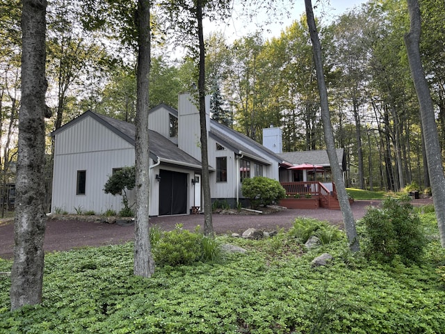 1161 Deer, Pocono Pines, PA 18350 - view of front of home with a chimney, a garage, asphalt driveway, a wooden deck, and roof with shingles