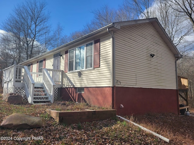 view of home's exterior with crawl space, stairs, and a wooden deck