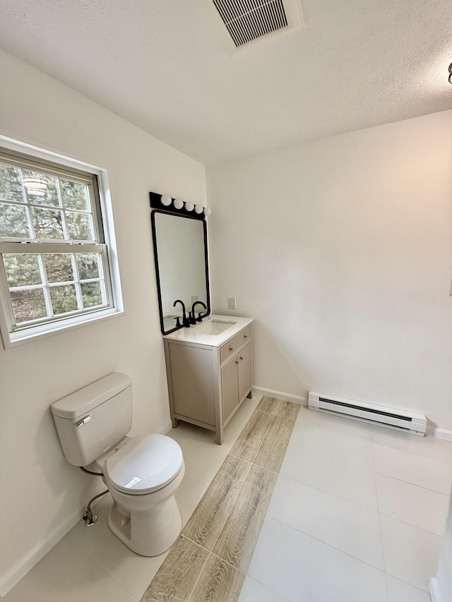 bathroom featuring visible vents, baseboards, toilet, vanity, and a baseboard heating unit