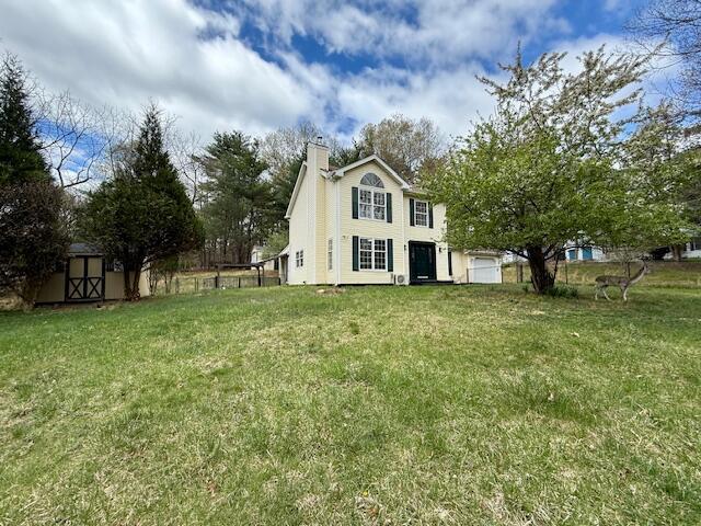 113 Dennis Ct, East Stroudsburg, PA 18301 - back of house with a chimney, a yard, fence, an outbuilding, and a storage shed