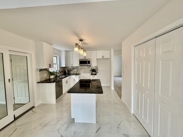 kitchen featuring marble finish floor, decorative backsplash, stainless steel appliances, and a sink