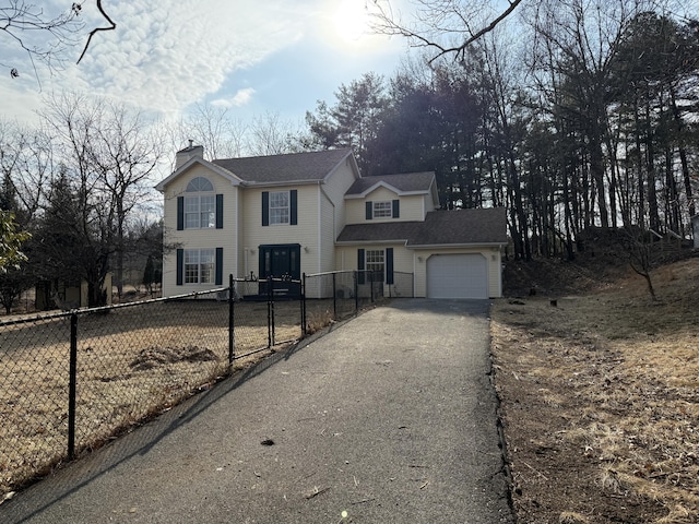 colonial house with a garage, fence private yard, driveway, and a chimney