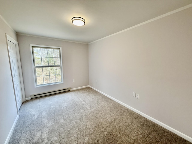 carpeted spare room featuring a baseboard heating unit, crown molding, and baseboards