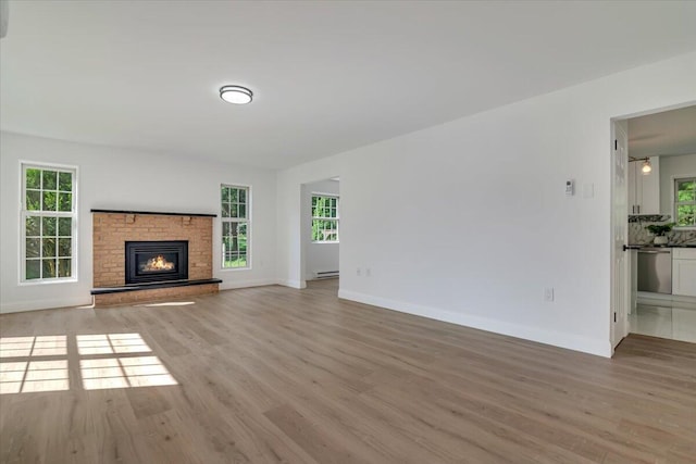 113 Dennis Ct, East Stroudsburg, PA 18301 - unfurnished living room with light wood-type flooring, a fireplace, and baseboard heating