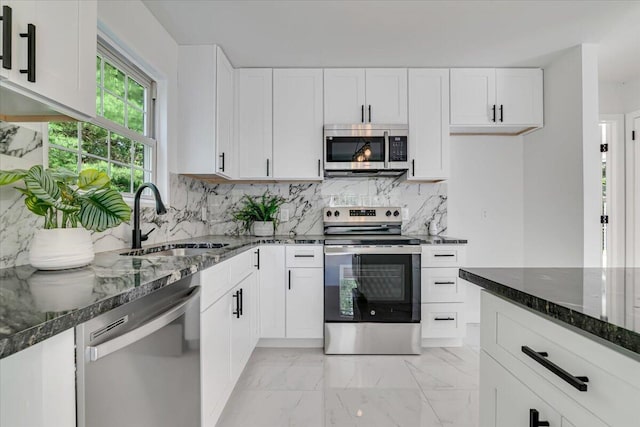 113 Dennis Ct, East Stroudsburg, PA 18301 - kitchen with appliances with stainless steel finishes, light marble finish flooring, dark stone counters, and tasteful backsplash
