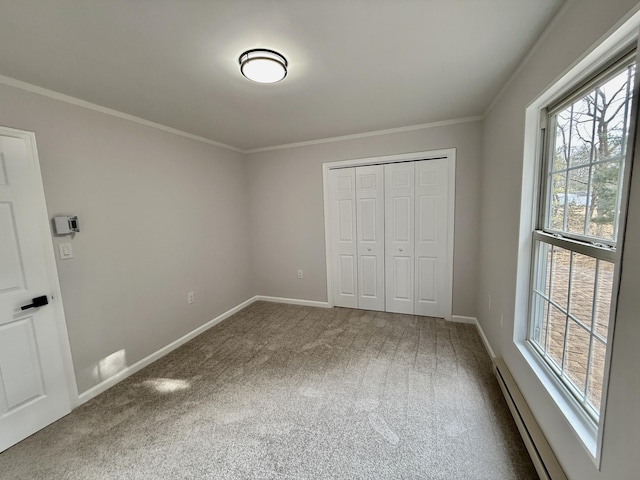 unfurnished bedroom with a baseboard heating unit, carpet flooring, and ornamental molding