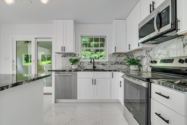 113 Dennis Ct, East Stroudsburg, PA 18301 - kitchen featuring stainless steel appliances, dark stone counters, decorative backsplash, white cabinets, and light marble finish flooring