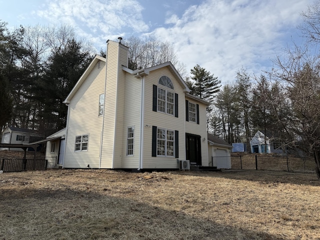 exterior space featuring a garage, fence, and a chimney