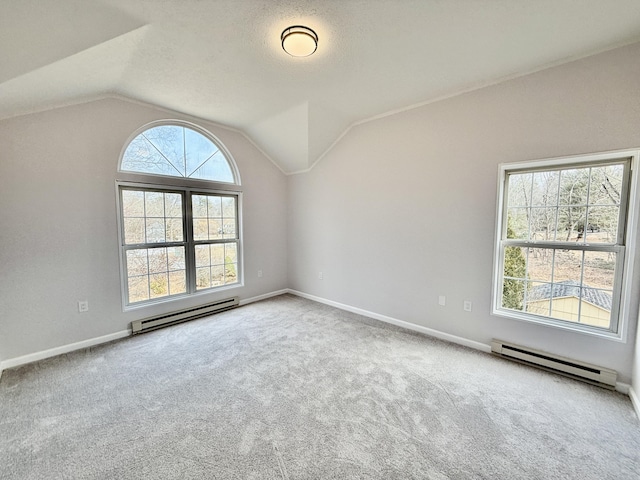 spare room with lofted ceiling, baseboard heating, carpet flooring, and baseboards