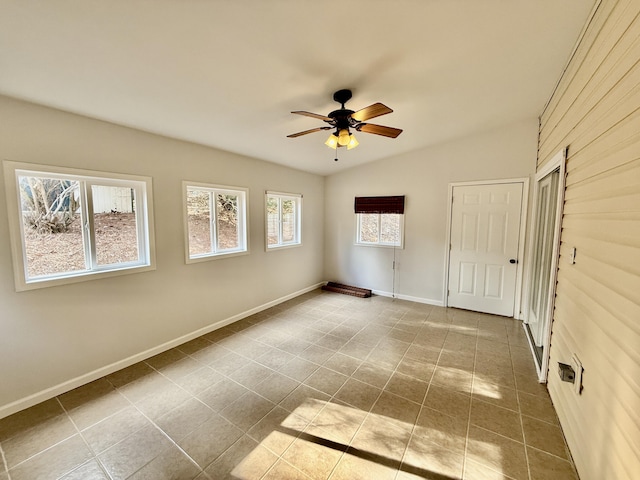 tiled spare room with lofted ceiling, ceiling fan, and baseboards