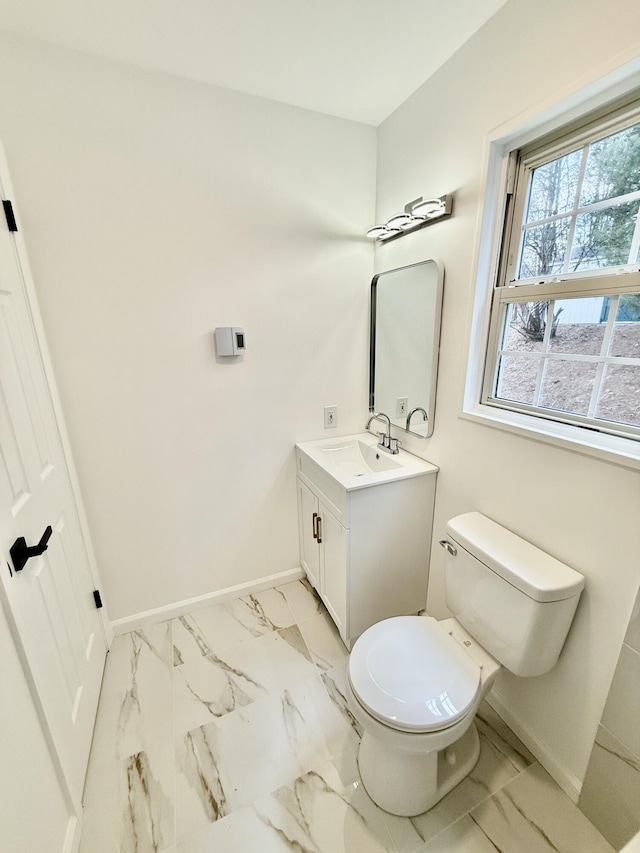 bathroom with marble finish floor, baseboards, vanity, and toilet