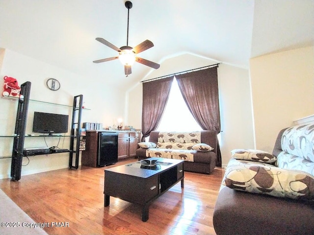 living room featuring ceiling fan, high vaulted ceiling, and light wood-type flooring