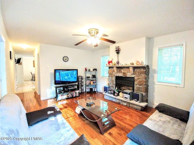 living room with hardwood / wood-style flooring, ceiling fan, a healthy amount of sunlight, and a fireplace