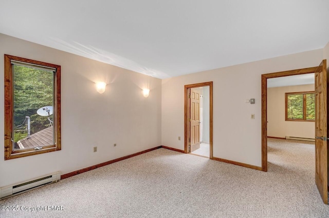 empty room with light colored carpet and baseboard heating