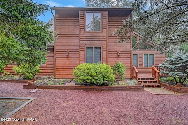 rear view of house featuring a wooden deck