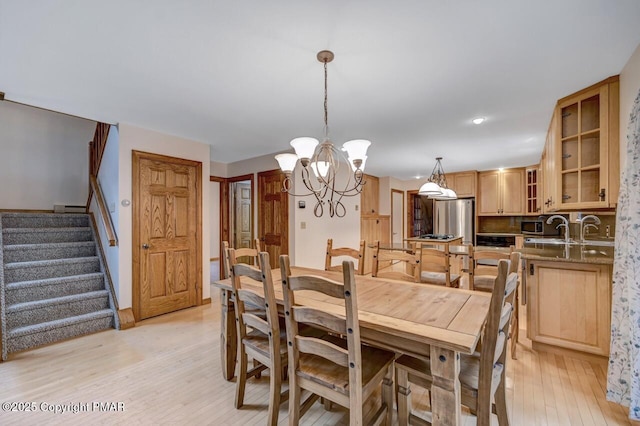 dining area featuring a notable chandelier, light hardwood / wood-style flooring, and baseboard heating