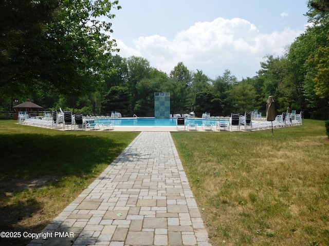 view of swimming pool with a lawn