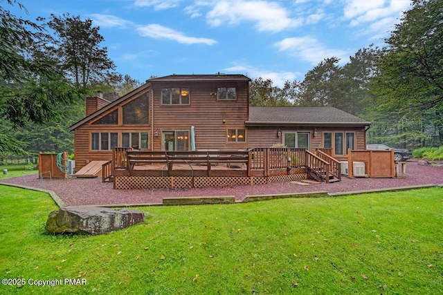 rear view of property featuring a wooden deck and a yard