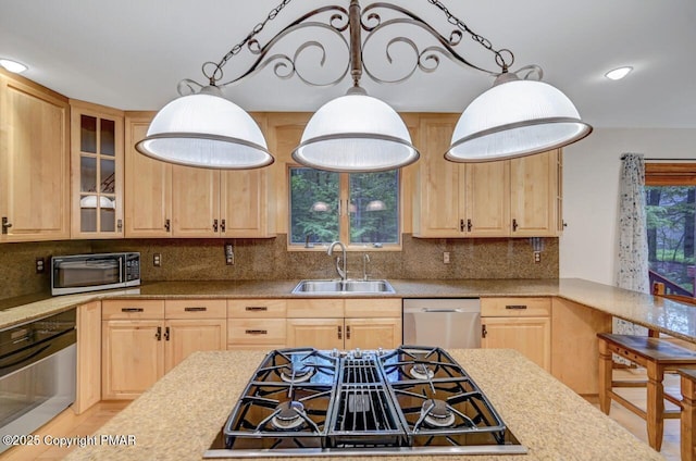 kitchen with appliances with stainless steel finishes, tasteful backsplash, sink, hanging light fixtures, and light brown cabinets